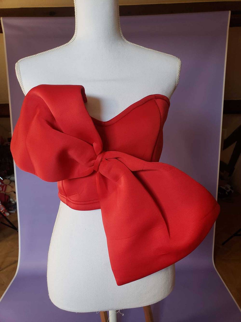 C'est un haut à nœud de couleur rouge,acheter sur Ar Backdrops  Il y a fermeture éclair au dos, taille unique, mais d'apres une collègue, elle irait pour des petits bustes avec une poitrine max 90C,elle n'a pas été encore portée